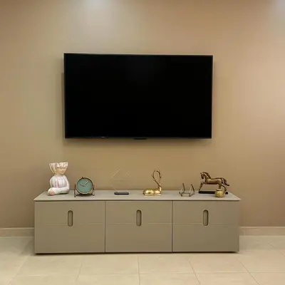 a flat screen tv on a wall with a dresser at Appartement Confort & Sérénité Mabroka Marrakech in Marrakech