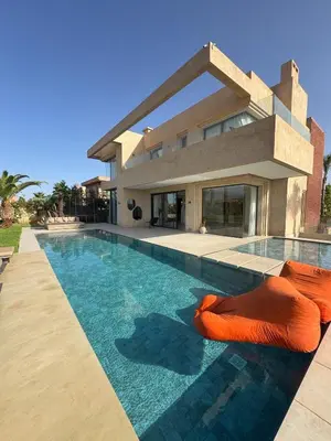 a swimming pool in front of a house at Villa NAHA in Marrakech