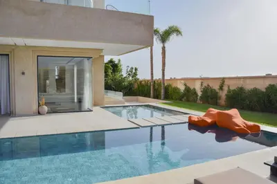 a swimming pool in front of a house at Villa NAHA in Marrakech