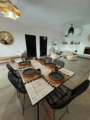 a table and chairs in a room with a table and chairsktop at Villa Selma piscine privée sans vis à vis 9 min du centre in Marrakech