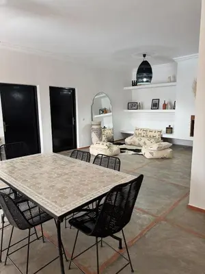 a dining room with a table and chairs in a room at Villa Selma piscine privée sans vis à vis 9 min du centre in Marrakech