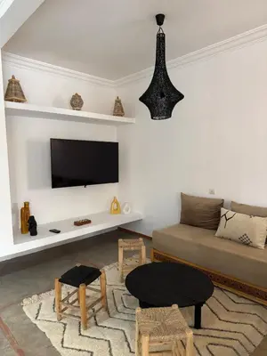 a living room with a couch and a flat screen tv at Villa Selma piscine privée sans vis à vis 9 min du centre in Marrakech