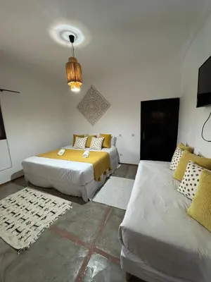 a bedroom with two beds and a couch in it at Villa Selma piscine privée sans vis à vis 9 min du centre in Marrakech