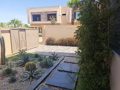 a house with a fence and some plants in a yard at Villa Starlight in Marrakech