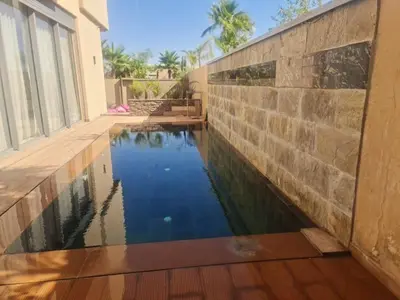 a swimming pool in the side of a house with a stone wall at Villa Starlight in Marrakech