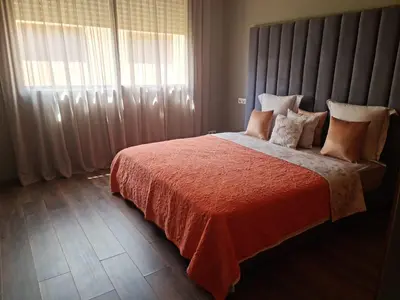 a bedroom with a bed with a red comforter and a window at Villa Starlight in Marrakech