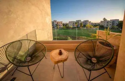 two chairs sitting on a balcony with a window at Appartement luxe avec vue imprenable sur le golf in Marrakech