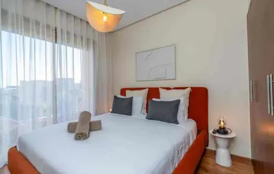 a bedroom with a large bed with a large window at Appartement luxe avec vue imprenable sur le golf in Marrakech