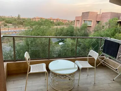 a balcony with a table and chairs and a view at studio design prestigia jad in Marrakech