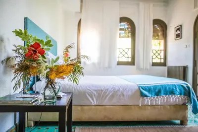 a bedroom with a bed and a table with flowers at La Vie En Rose - Horses & Dogs House in Marrakech