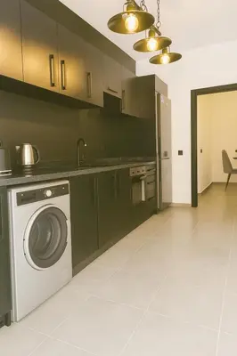 a kitchen with a washing machine and a sink at Cozy Appartement avec jacuzzi chauffant in Marrakech
