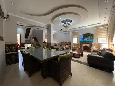 a large living room with a table and a couch at Villa zinaya in Marrakech