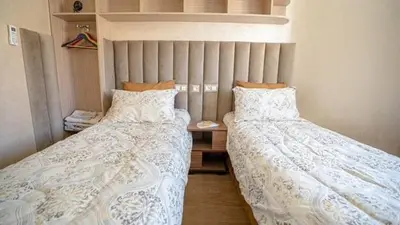 two beds sitting next to each other in a bedroom at Bel appart vue piscine dans résidence sécurisée in Marrakech