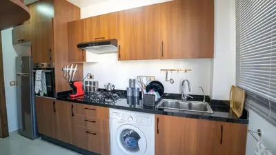 a kitchen with a sink and a washing machine at Bel appart vue piscine dans résidence sécurisée in Marrakech
