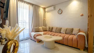 a living room with a couch and a table at Bel appart vue piscine dans résidence sécurisée in Marrakech