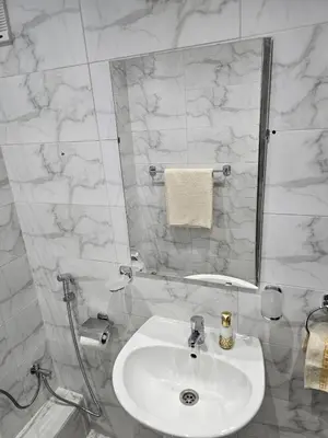 a white bathroom with a sink and a mirror at Central Bright Comfortable in Marrakech