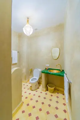 a bathroom with a toilet and a green counter top at Riad Lalla Fatima Marrakech in Marrakech