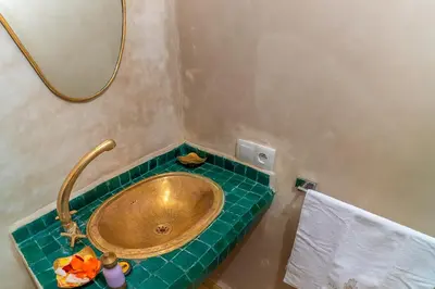 a bathroom with a gold sink and a mirror at Riad Lalla Fatima Marrakech in Marrakech