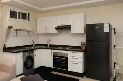 a kitchen with a black refrigerator and a dishwasher at Superbe Duplex moderne à Izdihar in Marrakech