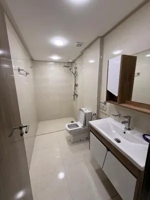 a white bathroom with a toilet and a sink at حدائق حي شريفية بوعكاز مراكش in Marrakech