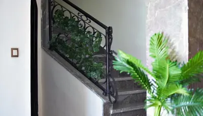 a metal railing with plants on a stair case at la villa cozy in Marrakech