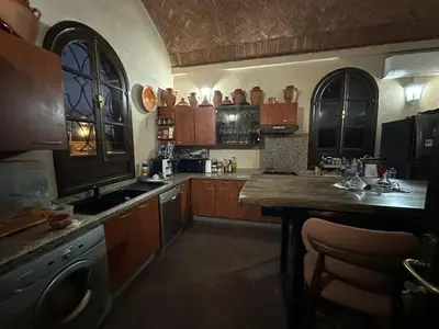 a large kitchen with wooden cabinets and a table at Riad Wael in Marrakech