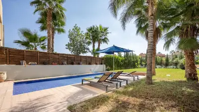 a swimming pool with lounge chairs and palm trees at Villa de luxe in Marrakech