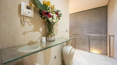 a bathroom with a glass counter with a vase of flowers at Villa de luxe in Marrakech