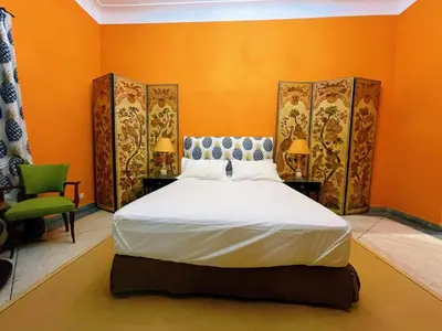 a bedroom with a large bed with orange walls at Maison Yves st Laurent - Piscine in Marrakech