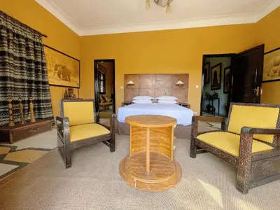 a bedroom with a bed and two chairs and a table at Maison Yves st Laurent - Piscine in Marrakech