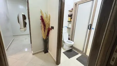 a bathroom with a toilet and a vase of flowers at Private Apartment Near Marrakech Airport in Marrakech