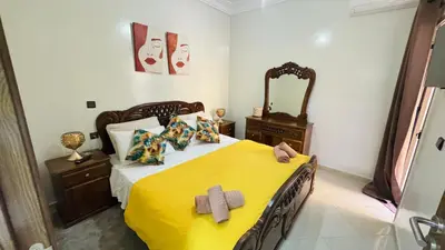 a bedroom with a large bed with a yellow blanket at Private Apartment Near Marrakech Airport in Marrakech
