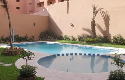 a swimming pool in front of a building at Appartement en plein cœur de Marrakech in Marrakech