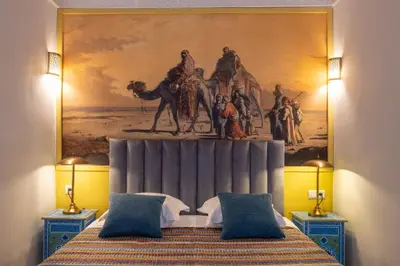 a bedroom with a painting on the wall above a bed at Palais el Abbassia in Marrakech