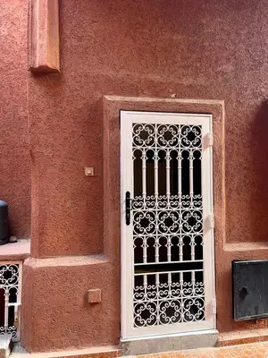 a door with a gate on the side of a building at Riad Nora - Confort, Calme & Sécurité in Marrakech