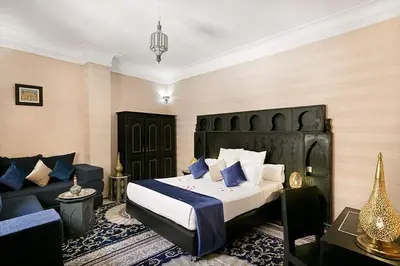 a hotel room with a bed and a couch at Arabian Riad Marrakech in Marrakech