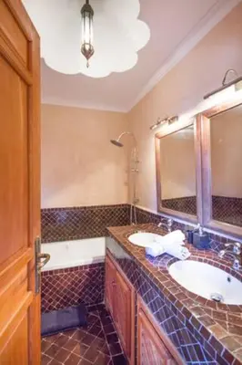 a bathroom with two sinks and a large mirror at Arabian Riad Marrakech in Marrakech