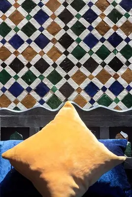 a yellow pillow sitting on a bed in front of a wall at Arabian Riad Marrakech in Marrakech