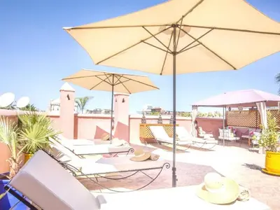 a group of chairs and umbrellas on a patio at Arabian Riad Marrakech in Marrakech