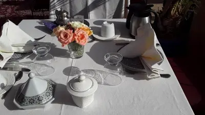 a white table with a vase of flowers on it at Arabian Riad Marrakech in Marrakech