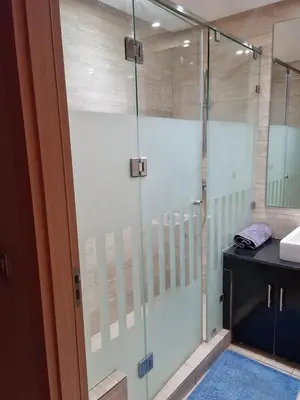 a glass shower door in a bathroom with a sink at marrakech village in Marrakech