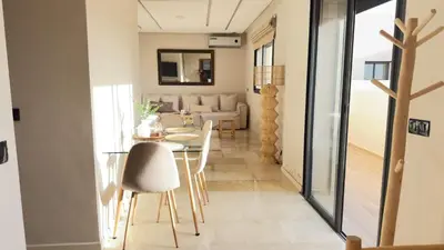 a dining room and living room with a table and chairs at Calm Cozy Blue Loft Modern Stay in Marrakech