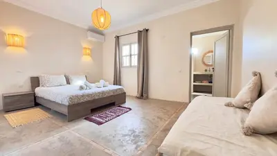 a bedroom with a bed and a couch and a mirror at Villa Bella Marrakech avec piscine sans vis-à-vis 9 min du centre in Marrakech