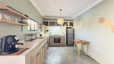 a large kitchen with a counter and a table at Villa Bella Marrakech avec piscine sans vis-à-vis 9 min du centre in Marrakech