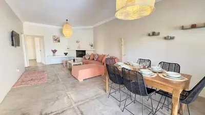 a living room with a table and chairs and a couch at Villa Bella Marrakech avec piscine sans vis-à-vis 9 min du centre in Marrakech