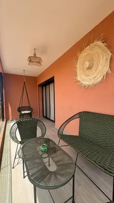 a room with two green chairs and a glass table at Domaine Noria - Modern apartment, quiet & 4 pools in Marrakech