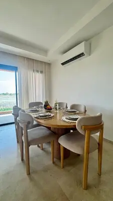 a dining room with a wooden table and chairs at Domaine Noria - Modern apartment, quiet & 4 pools in Marrakech