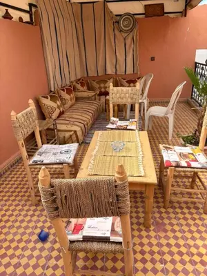 a living room with a couch and tables and chairs at Dar Adil à 5 min from Jemaa el fna médina in Marrakech