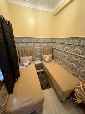 two beds in a room with a wall at Dar Adil à 5 min from Jemaa el fna médina in Marrakech