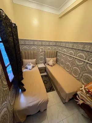 a room with two beds in a room at Dar Adil à 5 min from Jemaa el fna médina in Marrakech
